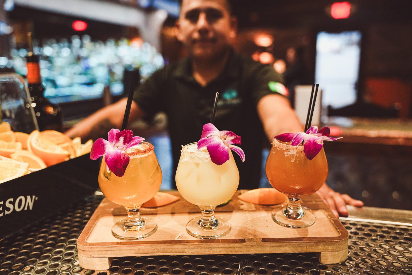 Bartender serving flower-garnished cocktails